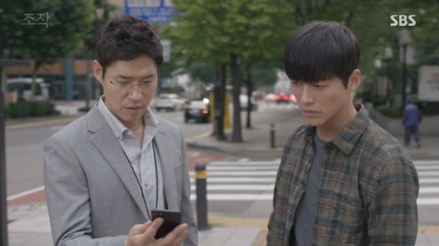 Seok-min being contacted by his informant in front of Moo-yeong